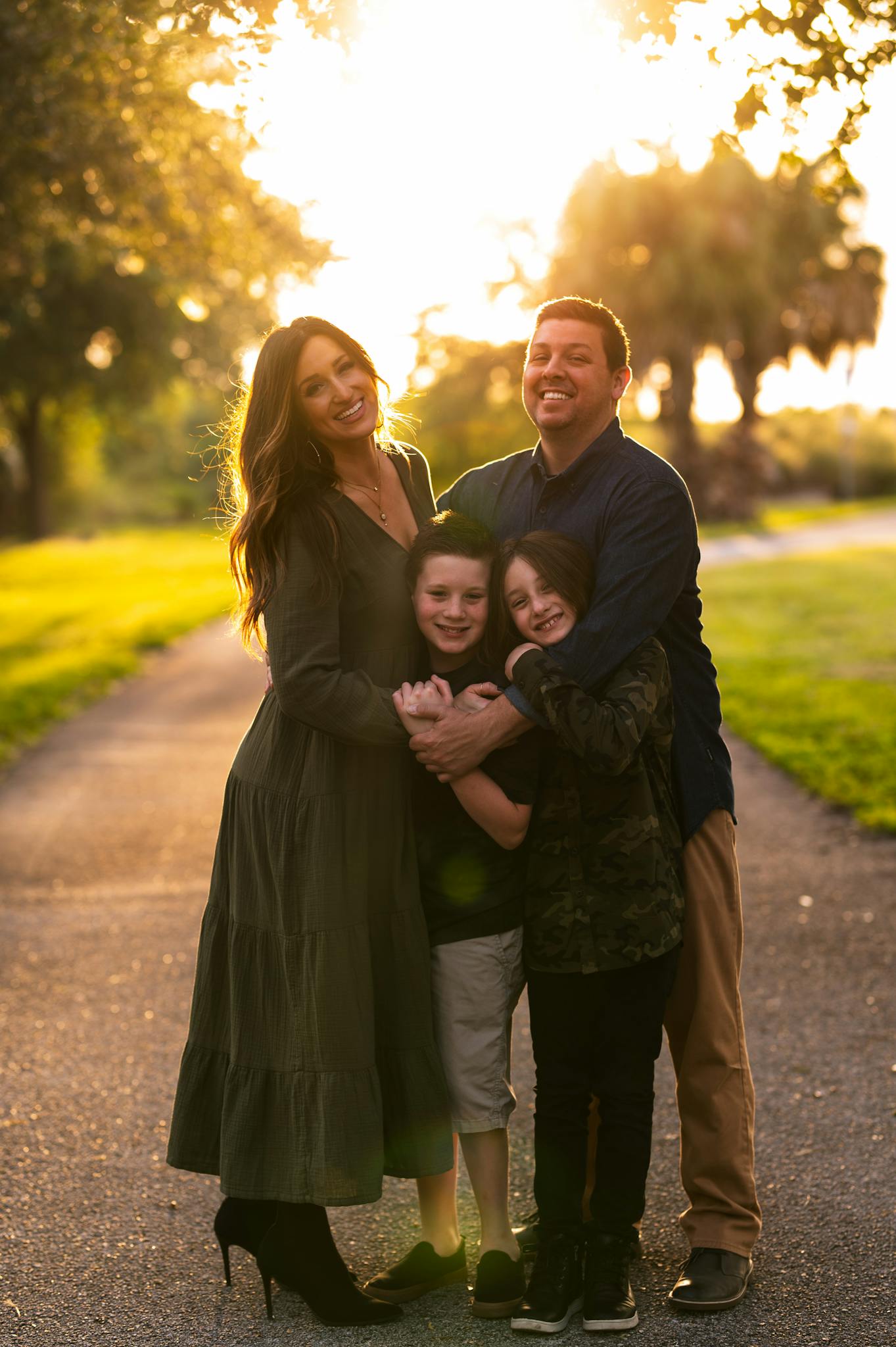 Smiling family posing together at a sunset in Tampa, creating a warm and joyful moment outdoors.